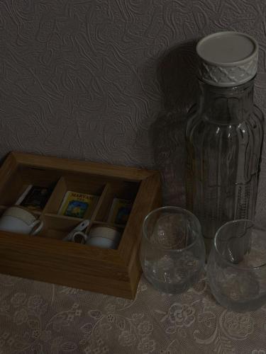 a wooden box with a vase and a bottle on a table at Philia's Guest House in Sighnaghi