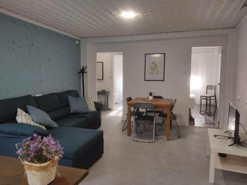 a living room with a blue couch and a table at Luminoso apartamento en centro del pueblo con Wifi y A' A' in Sagunto
