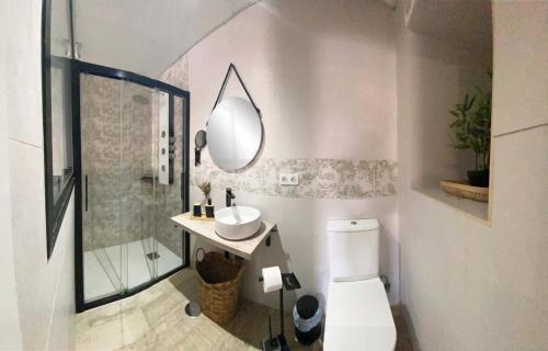 een badkamer met een toilet, een wastafel en een spiegel bij Amores Loft Rural in Alcalá de los Gazules