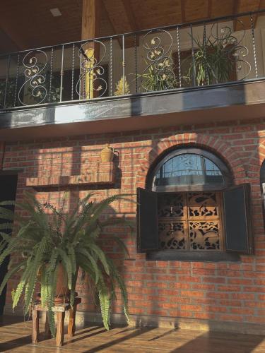 a brick building with a balcony and a window at Philia's Guest House in Sighnaghi