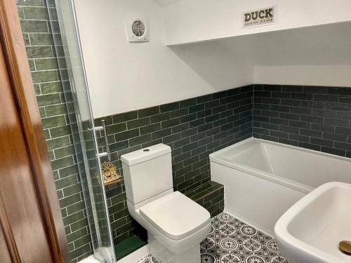 a bathroom with a toilet and a sink and a tub at No 11 Rooms in Haworth