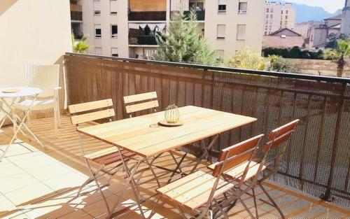 a wooden table and chairs on a balcony at Le palais Omnisport grand apt avec terrasse by Weekome in Marseille