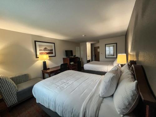 um quarto de hotel com duas camas e um sofá em Harbor Winds Hotel em Sheboygan