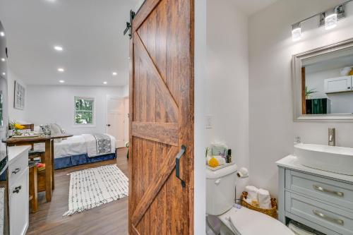 La salle de bains est pourvue d'une porte avec un lavabo et un lit. dans l'établissement Charming Danvers Studio 5 Mi to Salem!, à Danvers