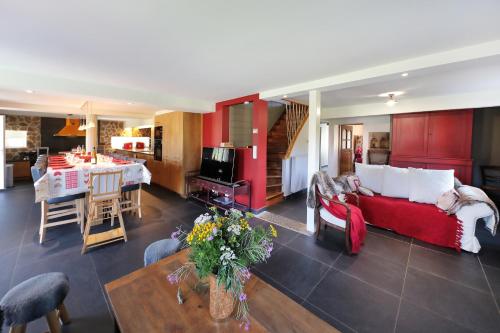 uma sala de estar com um sofá vermelho e uma mesa em Chez Odile - Charmante ferme rénovée em Gérardmer