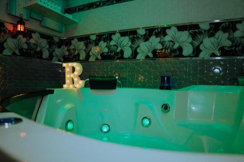 HOTEL RAYMONDI في بوكالبا: حمام مع حوض أخضر مع خطاب على الحائط