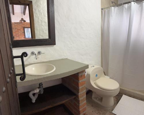 a bathroom with a sink and a toilet at Hotel Boutique Villa Isabel in Salento