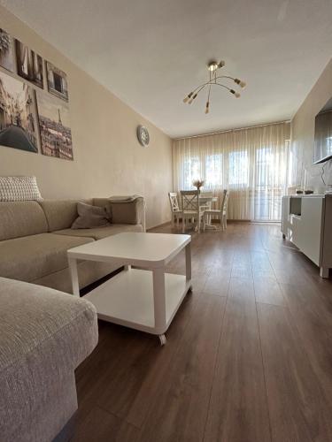 ein Wohnzimmer mit einem Sofa und einem Tisch in der Unterkunft Warsaw Apartments Wiatraczna in Warschau