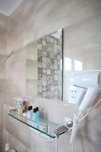 a bathroom with a blow dryer and a mirror at Breathe Inn in Batumi