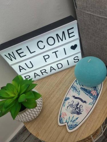a table with a potted plant and a sign at Résidence du Golf Evergreen Au Pti'Paradis in Saint-François