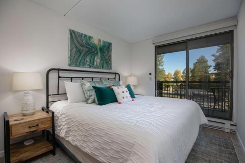 a bedroom with a bed and a large window at Trails End Alpine Dream Condo: Ski In/Out, Walk to Town in Breckenridge