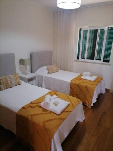 una camera d'albergo con due letti e asciugamani di Caniço Ocean Getaway a Caniço