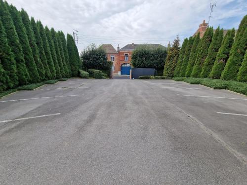 un estacionamiento vacío frente a una casa en Le domaine de la Rhonelle en Villers-Pol