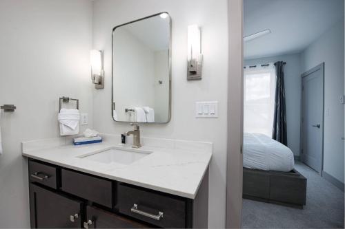 a bathroom with a sink and a mirror and a bed at Fourth Street Crossing Traverse Townhome: Stylish Retreat in Silverthorne
