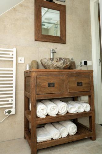 a bathroom with a sink and a pile of towels at Vakantieverblijf Weidezicht in Dorst