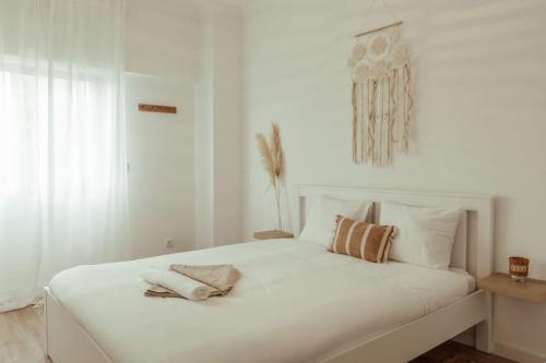 a white bedroom with a large white bed with pillows at 3 bedroom apartment in Cacém in Paiõis