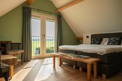a bedroom with a bed and a large window at Vakantieverblijf Weidezicht in Dorst