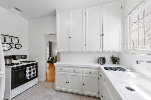 een witte keuken met een wastafel en een fornuis bij Beverly Hills Stylish & Central 1 BR Apt + Parking in Los Angeles