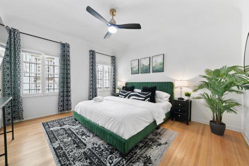 a bedroom with a green bed and a ceiling fan at Beverly Hills Stylish & Central 1 BR Apt + Parking in Los Angeles