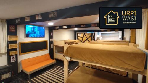 普諾的住宿－Urpi Wasi Backpackers，一间设有床铺和电视的房间