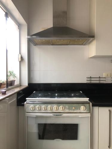 una cucina con forno e microonde sopra di esso di Energia Perfeita Casa Solar Milagres a Americana