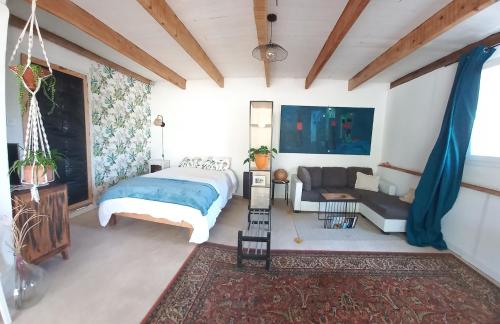 ein Schlafzimmer mit einem Bett und einem Sofa in der Unterkunft Les Jasmins in Roquebrune-sur-Argens
