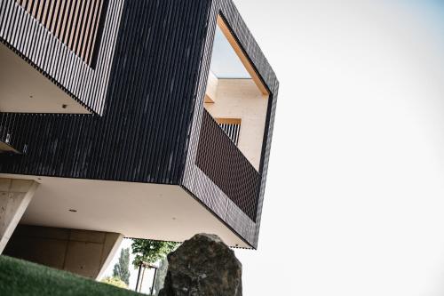 an external view of a house with a black roof at Stock & Stein Lodges in Bad Gleichenberg