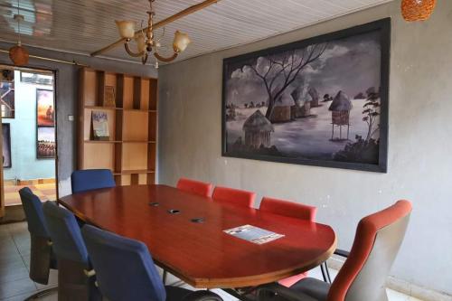 a dining room with a wooden table and blue chairs at The Nido Hotel in Meru