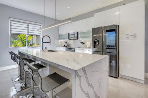 a kitchen with a large marble counter and a refrigerator at Deco Delight - Central Hub in Miami