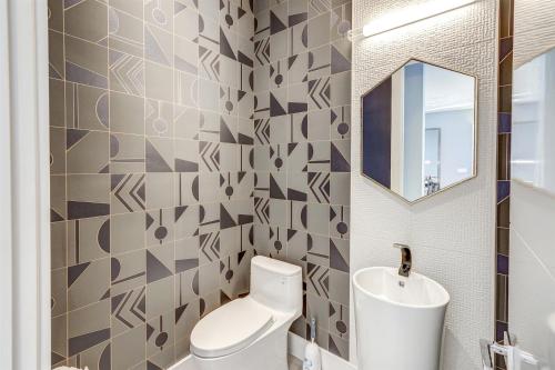 a bathroom with a toilet and a sink and a mirror at Deco Delight - Central Hub in Miami