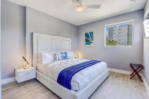 a white bedroom with a large bed and a window at Luxury, Art, design, patio grill, near Gables,Grove,Brickell in Miami