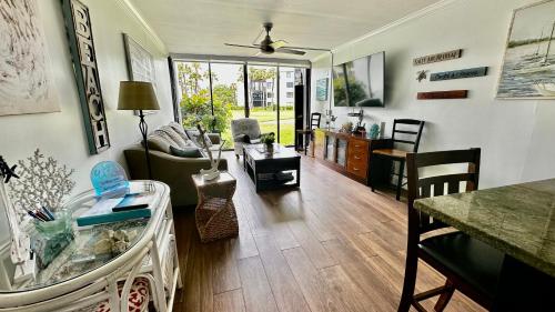 a living room with a couch and a table at Excellent beach front community, golf course, tennis, sunny weather year round! in Fort Pierce