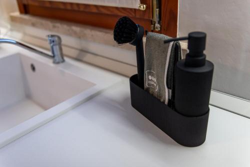 a black soap dispenser sitting next to a sink at Giustiniani Apartments in Treviso