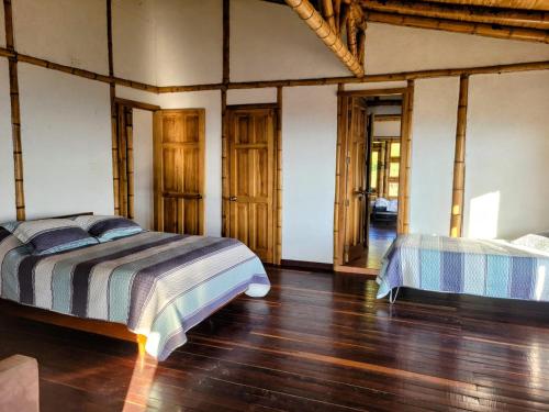 a bedroom with two beds and a wooden floor at LA MARQUESA PACORA in Pácora