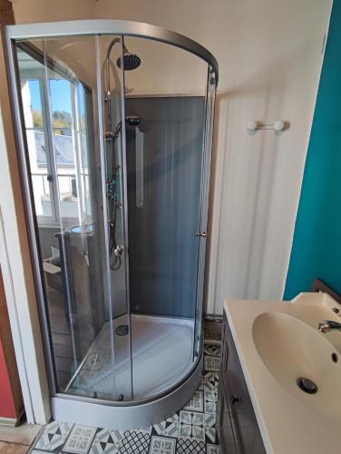 une douche en verre dans une salle de bain avec un lavabo dans l'établissement Gîte de la vallée à Courdemanche Sarthe, à Courdemanche
