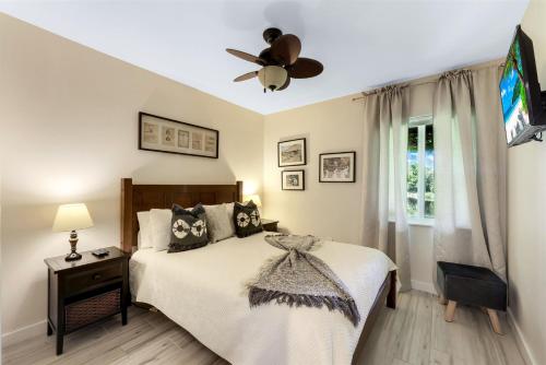 1 dormitorio con 1 cama y ventilador de techo en Lakefront, Pool, outdoor kitchen, lush garden en Naples