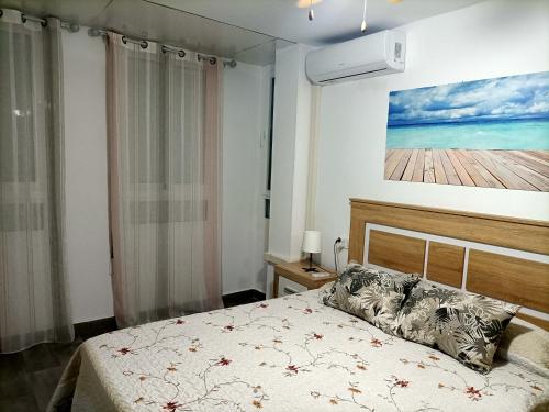 a bedroom with a bed and a painting on the wall at La Cubana II con Aire Acondicionado in Santa Pola