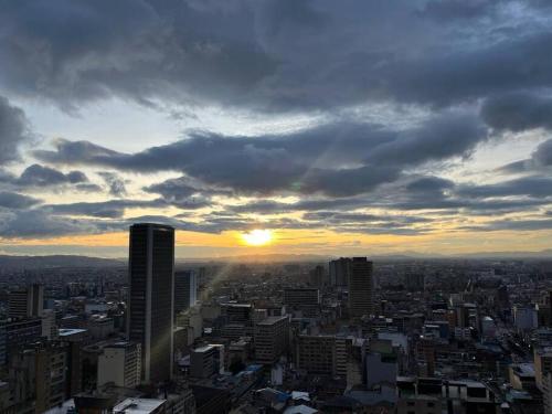 a city skyline with the sun setting in the sky at living ventto calle 18 in Bogotá