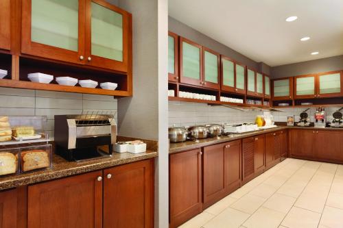 Una cocina con gabinetes de madera y encimera. en Hyatt House Denver Airport, en Denver
