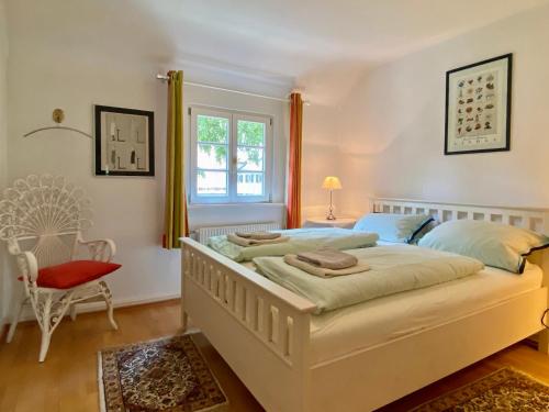 Ferienhaus Köchlin في لينداو: غرفة نوم بسريرين وكرسي احمر
