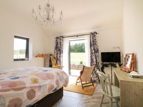 una camera con letto, scrivania e TV di The Cottage a Chesterfield