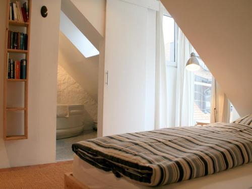 een slaapkamer met een bed en een groot raam bij Ferienwohnung Altes Haus 4 in Lindau