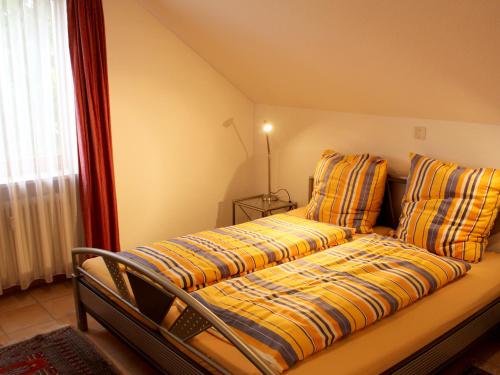 Bett mit gelber und blauer Bettdecke und Kissen in der Unterkunft Ferienwohnung Panorama pur in Lindau