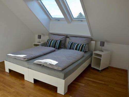 een bed in een kamer met een raam bij Ferienwohnung 180 Grad im 2 OG mit Panoramafenster See und Bergblick in Wasserburg