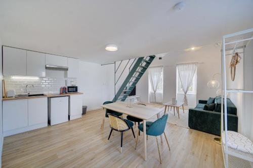 une cuisine et un salon avec une table et des chaises dans l'établissement Le Harmony - Appart'Escale, à Saint-Nazaire