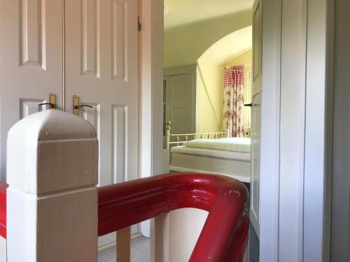 eine rote Bank in einem Zimmer mit einem Schlafzimmer in der Unterkunft Haus am See in Wasserburg