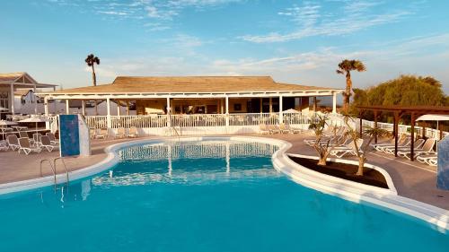 a large swimming pool with a building in the background at Caleta Dorada in Caleta De Fuste