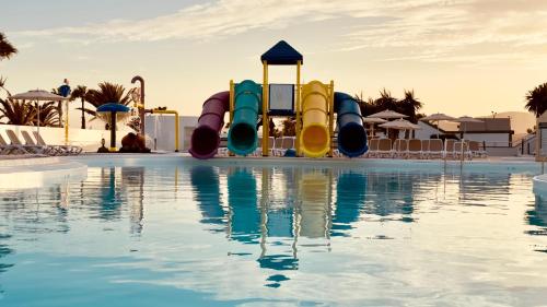 a pool with a water slide in a resort at Caleta Dorada in Caleta De Fuste