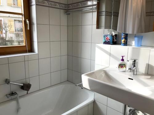 ein Badezimmer mit einer weißen Badewanne und einem Waschbecken in der Unterkunft Ferienwohnung Vera in Lindau-Bodolz