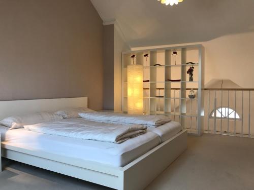 ein Schlafzimmer mit einem großen weißen Bett in einem Zimmer in der Unterkunft Ferienwohnung am Hopfengarten in Lindau
